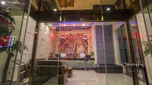 Un moderno vestíbulo con mostrador de recepción, zona de estar y decoración mural.