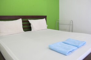 A bed with white bedding, two pillows, and two folded blue towels. - Tongmai Resort (Kanchanadit)