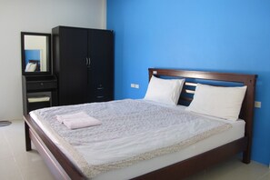 A bedroom with a bed, a wardrobe, and a mirror.