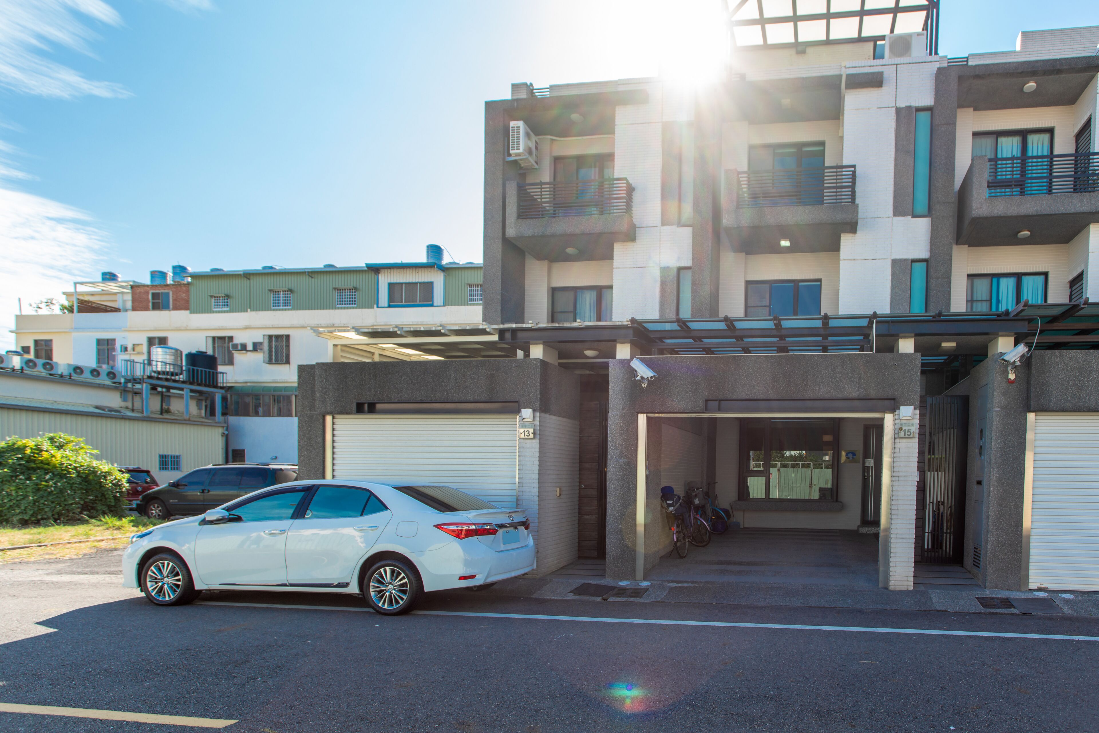 A multi-story building with a white car parked in front.