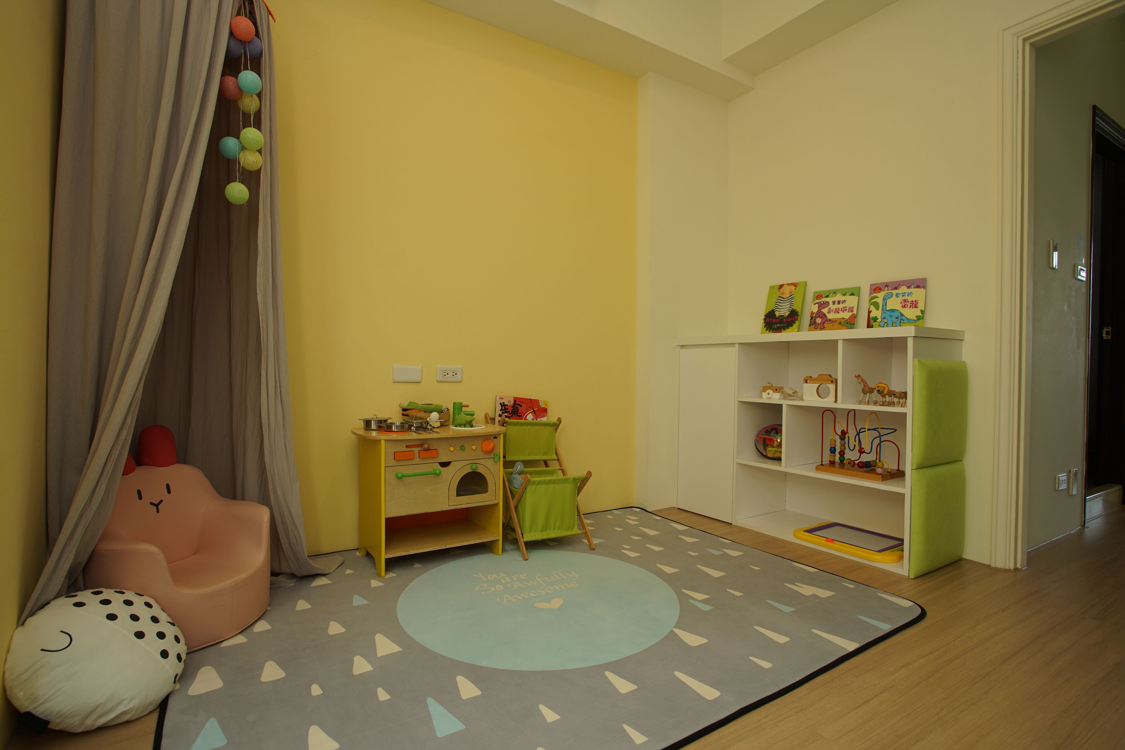 Un cuarto de juegos infantil con un escritorio, una silla y juguetes.