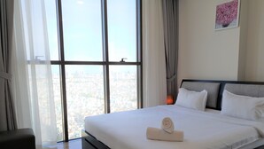 A hotel room with a large bed, a view of the city through floor-to-ceiling windows, a small table, and a wall-mounted painting. - Ami Splendid Rooftop Pool (Ho Chi Minh City)