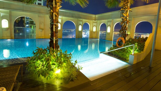 An indoor swimming pool with arched ceilings and a view of the city at night. - Ami Splendid Rooftop Pool (Ho Chi Minh City)