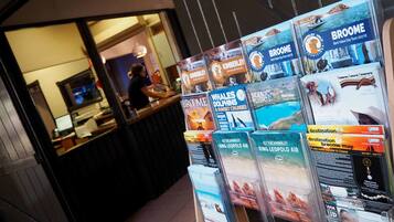 Une agence de voyages présente des brochures sur les circuits touristiques de Broome et de Kimberley, notamment des destinations où l’on peut observer des baleines, des dauphins et profiter de vols panoramiques.