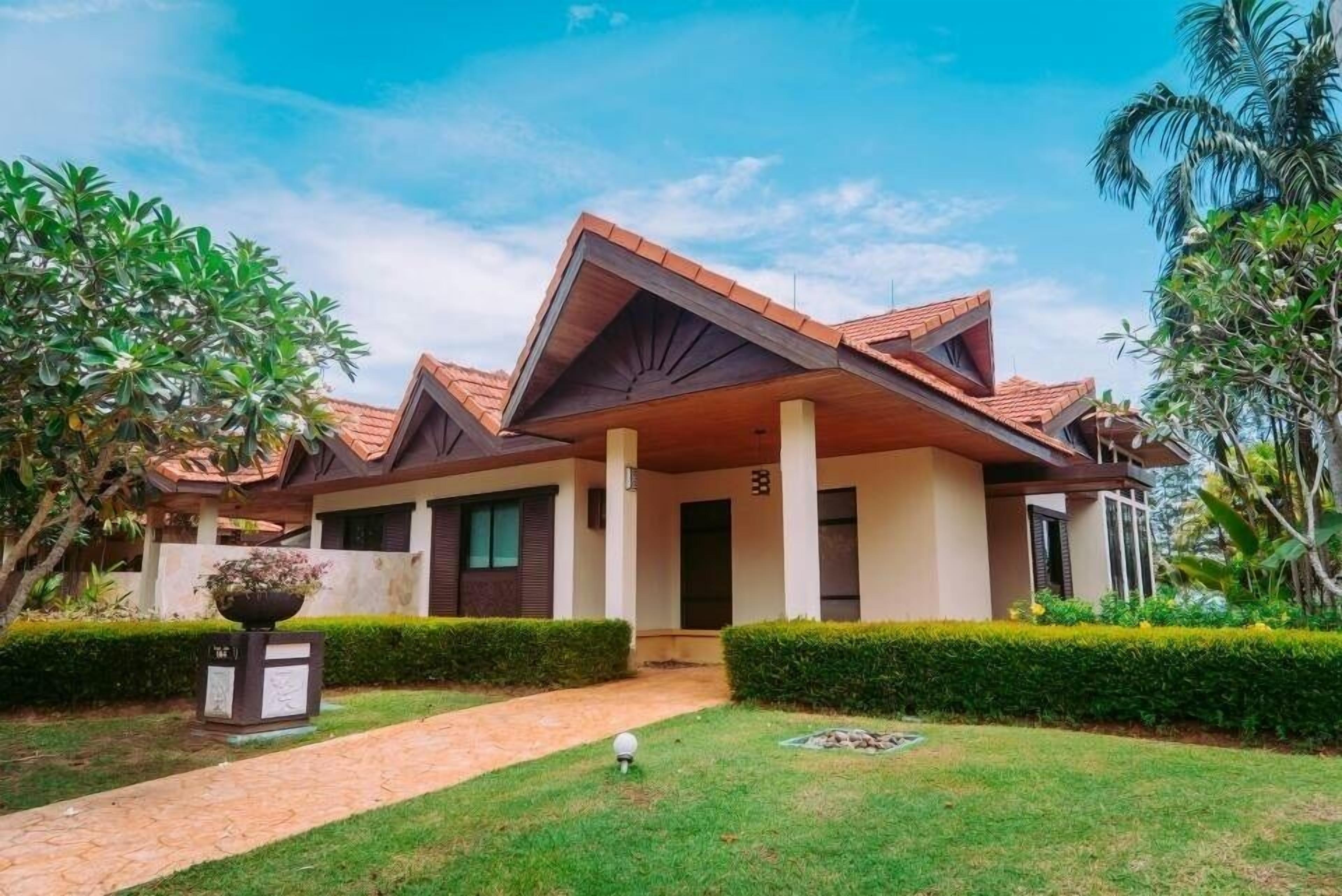 A modern house with a sloped roof, a front porch, and a well-maintained garden.