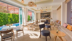 A modern interior with a dining area, seating, and a kitchen visible through an open door.