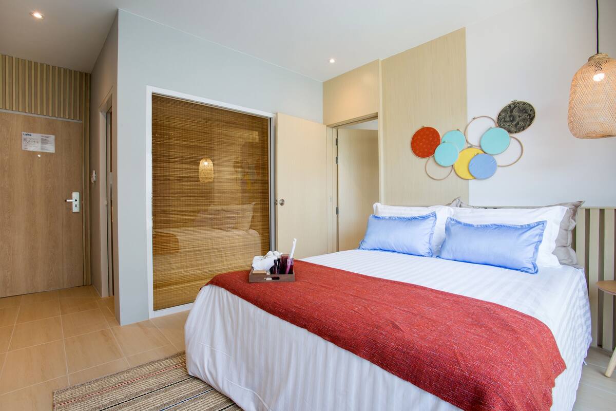 Una habitación de hotel con una cama grande, un armario de madera y una pared decorada con adornos circulares.