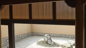 A traditional Japanese room with tatami flooring, a stone garden view, and wooden beams. - Stay Resort (Fenglin)