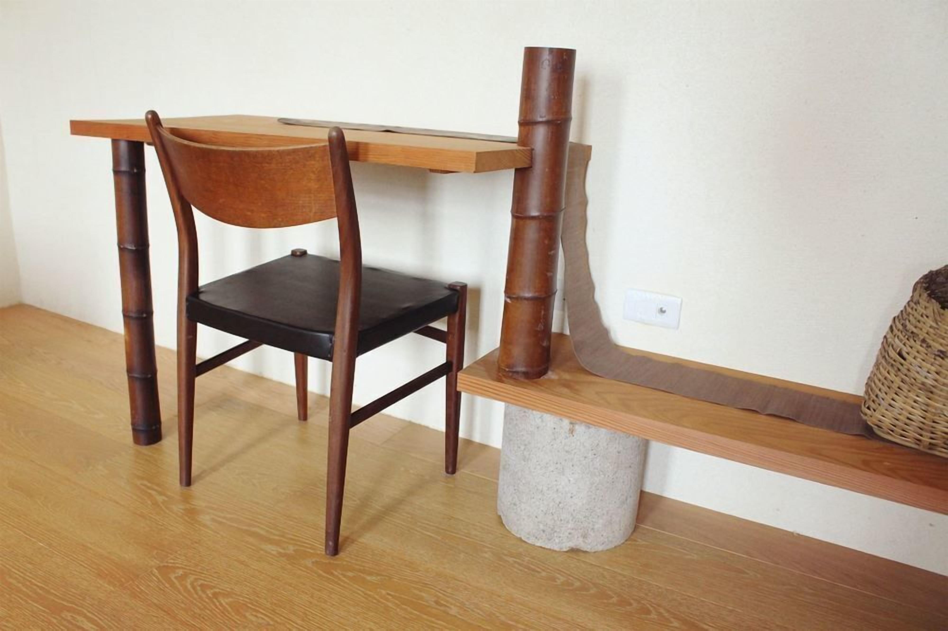 Una silla de madera con asiento negro y una mesa con tapa de madera.