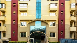 A multi-story building with a central entrance, balconies, and a symmetrical facade. - Citadel by New Crescent (Bengaluru)