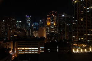 A nighttime cityscape with illuminated high-rise buildings. - Eton Residences by StayHome Asia (Makati)
