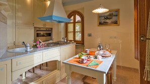 A kitchen with a large island, a stove, and a window. - San Bartolomeo LT (Passignano sul Trasimeno)