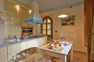 Una cocina con una isla grande, estufa y ventana.
