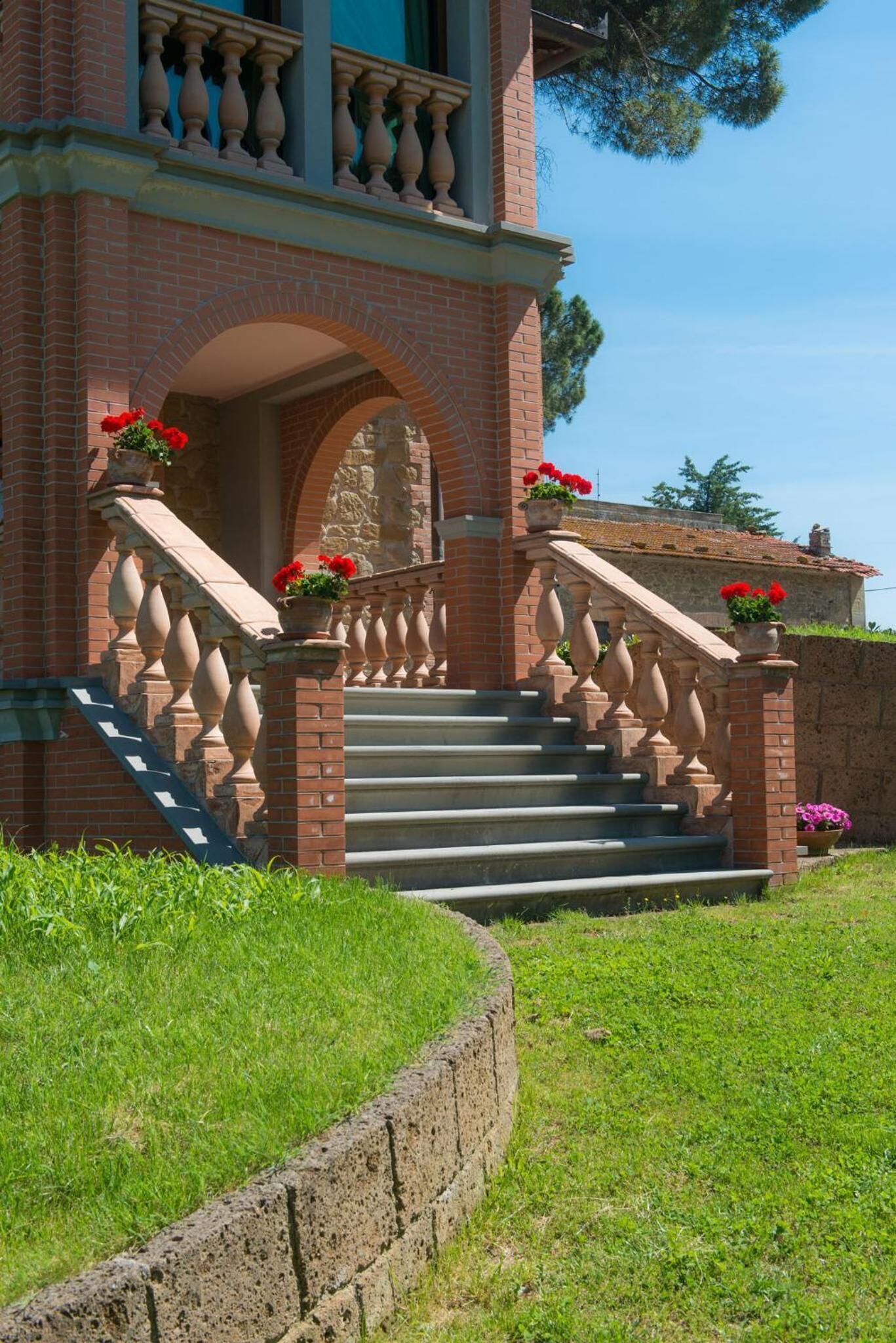 A brick building with a stone staircase leading to a balcony.