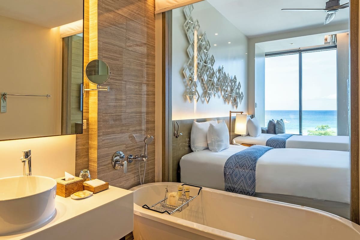 Une salle de bain moderne avec une grande baignoire sur pieds, un grand miroir rond et un grand lavabo.