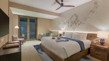 A modern hotel room with a large bed, a ceiling fan, a nightstand, a desk, and a view of the outside through a glass door.