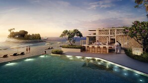 Un área junto a la piscina con sillones, un bar y vistas al océano.