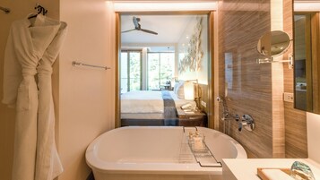 Un baño moderno con bañera, toallero y espejo.