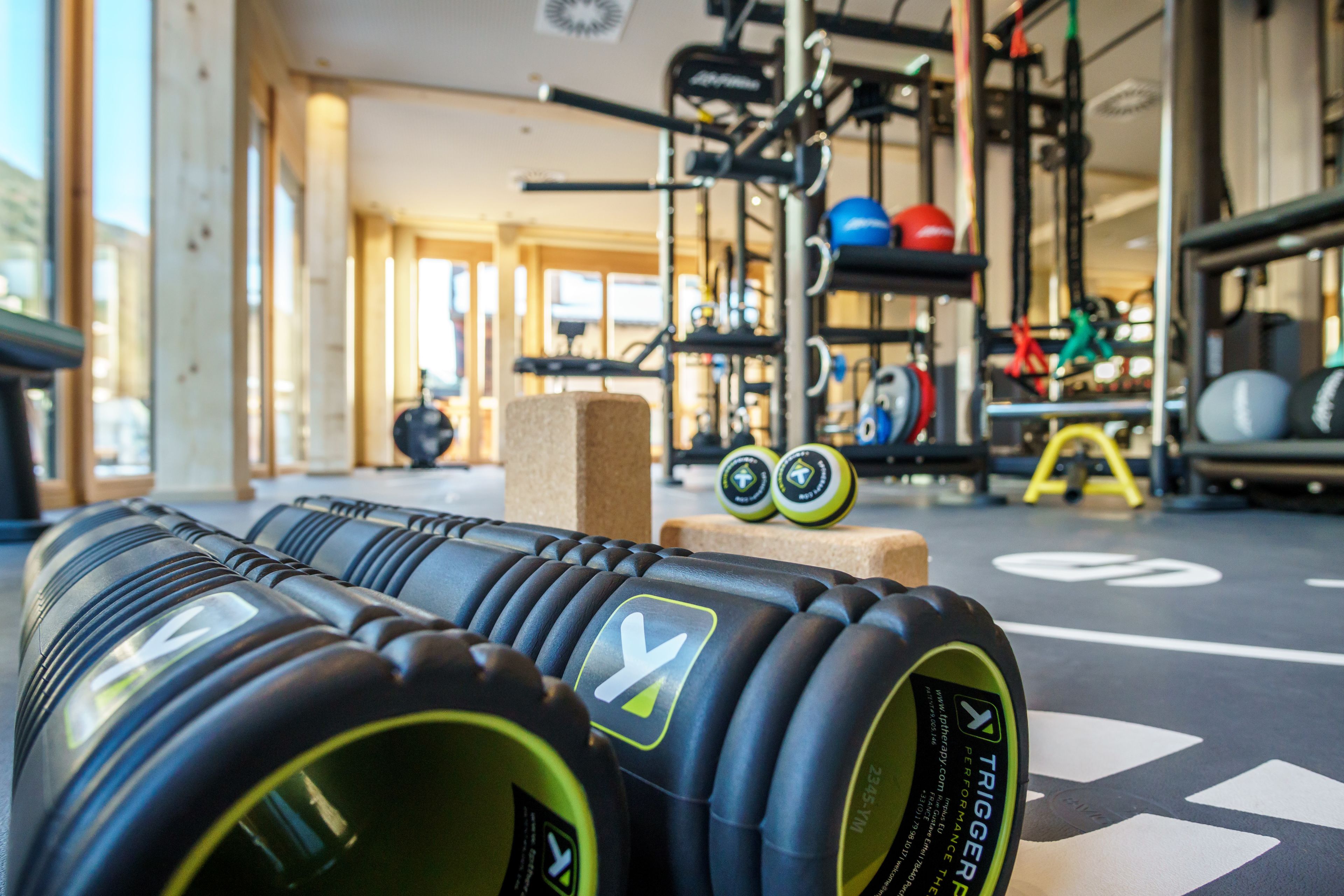 Un gimnasio con equipo de ejercicio, incluyendo pesas y una barra para sentadillas.