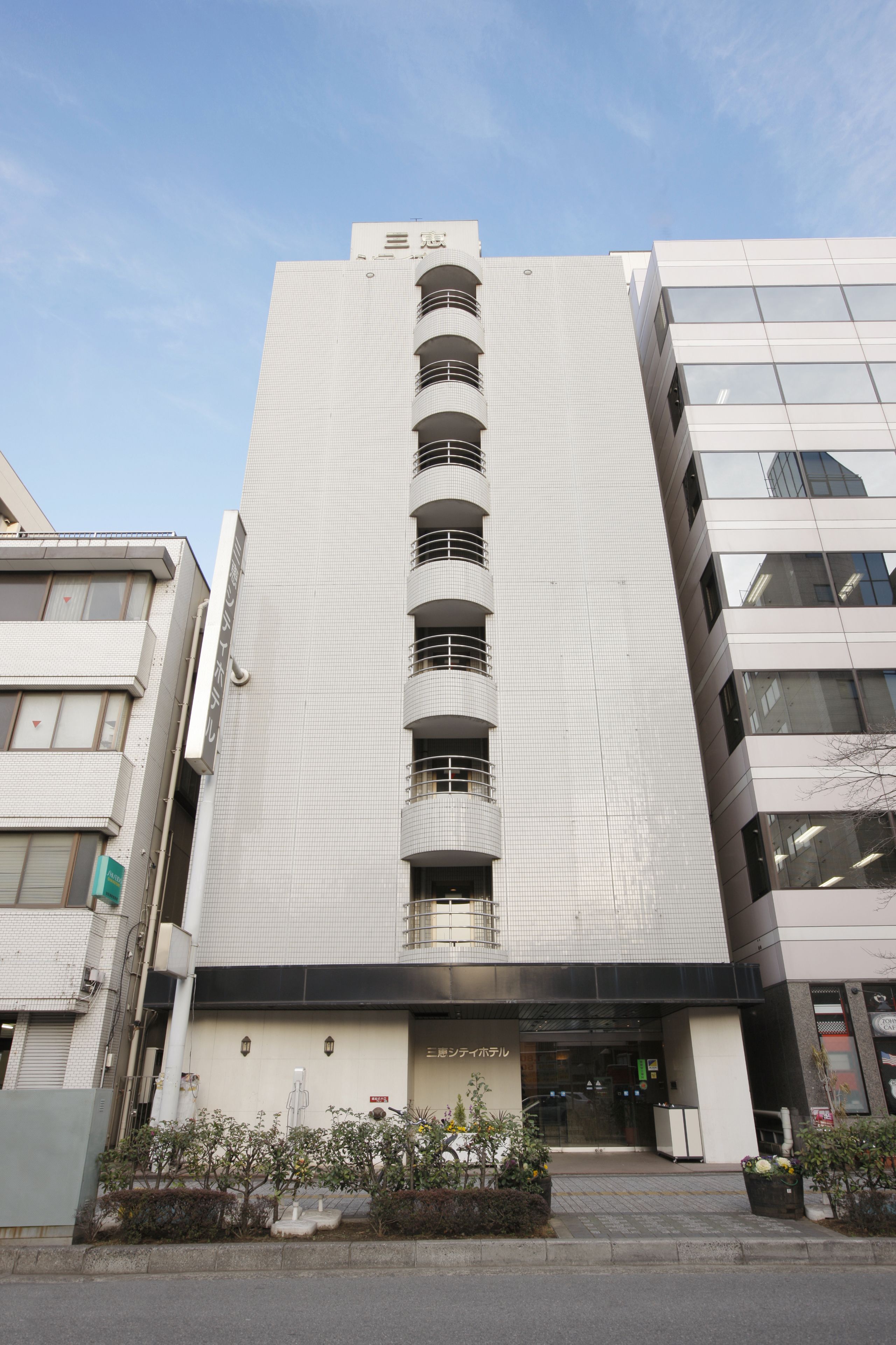 A modern building with a central staircase, large windows, and a flat roof.