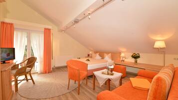 Een kamer met een bed, een bureau, een stoel en een bank.
