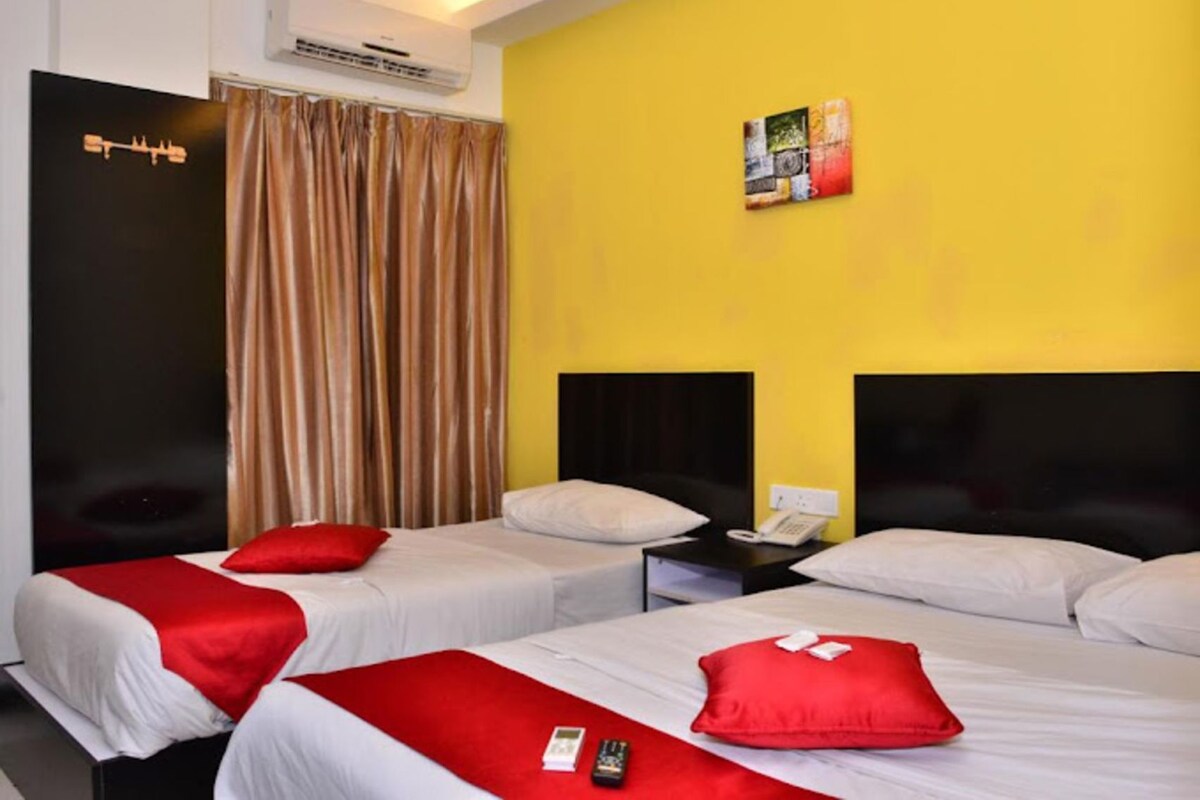 A hotel room with two beds, a telephone, and an air conditioning unit.