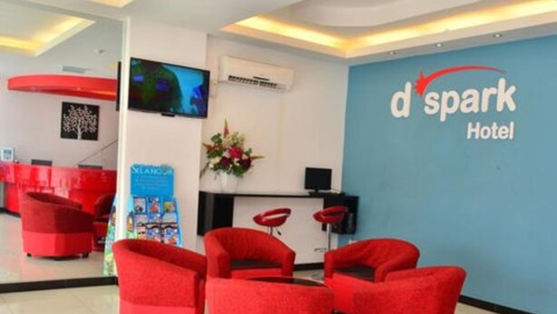 A reception area with red seating, a TV, a desk, and a 'd spark Hotel' sign. - Hotel O Dspark Port Klang (Pelabuhan Klang)
