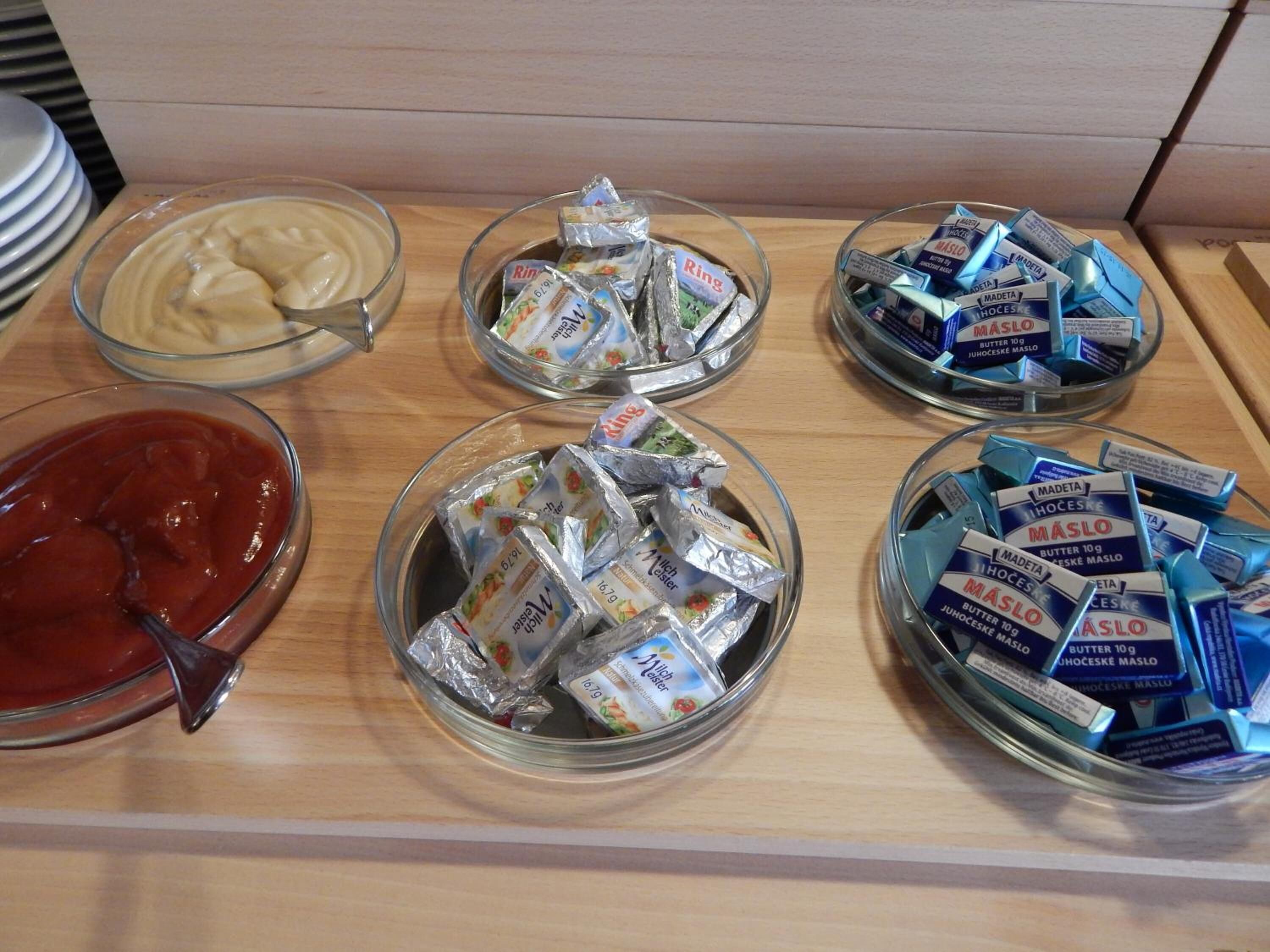 Une table de buffet proposant divers aliments, notamment des bols de crème, de beurre et des barres de chocolat.