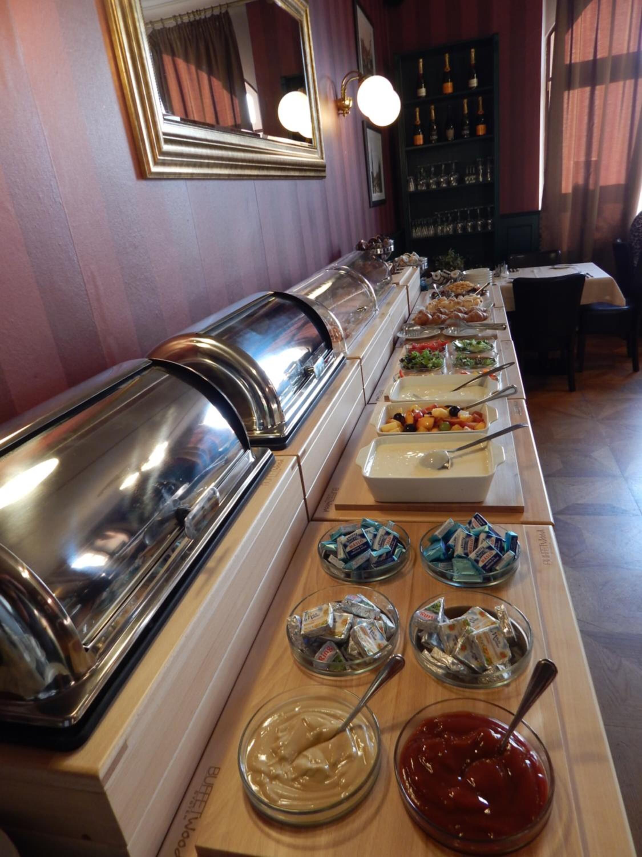 A buffet setup with various food items and condiments.