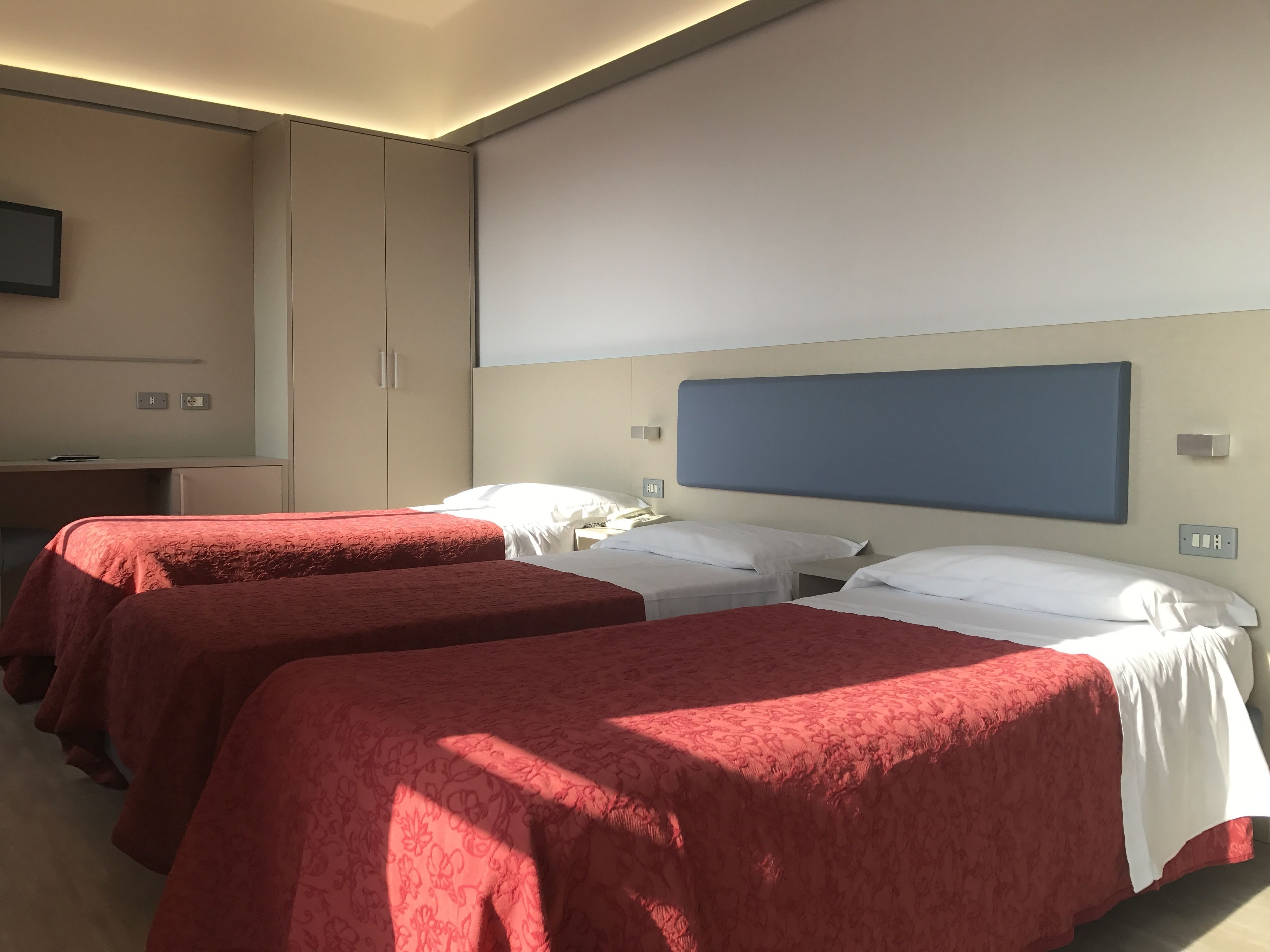 Ett hotellrum med två sängar, ett skrivbord och ett stort fönster.