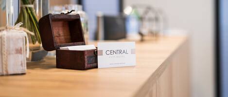 A wooden box with a nameplate reading "CENTRAL CITY HOTEL" on a wooden counter.