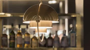 A bar area with a hanging light fixture and bottles in the background.