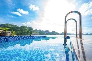 Una piscina infinita con vistas despejadas al mar y a las montañas.