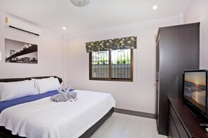 Une chambre d’hôtel équipée d’un lit, d’une télévision, d’une armoire, d’une fenêtre avec vue et d’un appareil de climatisation.