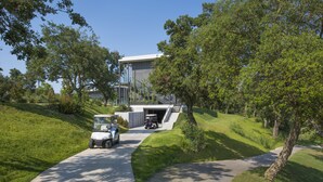 A modern building with a covered driveway and a golf cart parked in front.