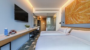 A modern hotel room with a large bed, a desk with a chair, a TV mounted on the wall, and a large abstract painting.