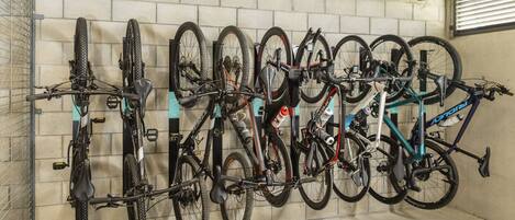 Un aparcaciclos con varias bicicletas aseguradas contra una pared.