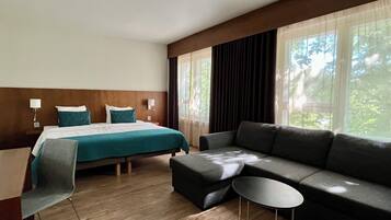 Une chambre d’hôtel avec un lit, un canapé, une petite table et une chaise.