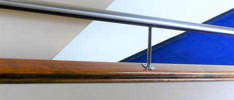 Una escalera con barandilla de metal y peldaños de madera.