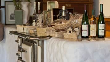 A vintage-style kitchen counter with a white marble top, a stainless steel cart, and three wine bottles.