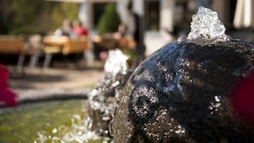 Une fontaine dont l’eau jaillit du sommet, entourée d’une structure en pierre.