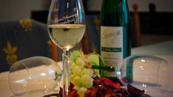 Un bicchiere di vino bianco su un tavolo, con una bottiglia e grappoli d'uva.
