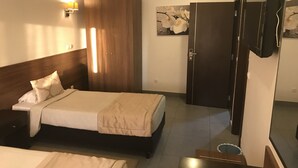 Une chambre d’hôtel équipée d’un lit, d’une armoire, d’un bureau et d’une télévision.