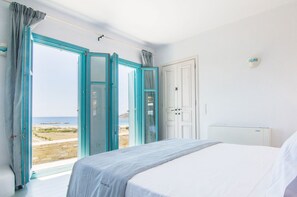 A bedroom with a bed, a wardrobe, and a bathroom door.