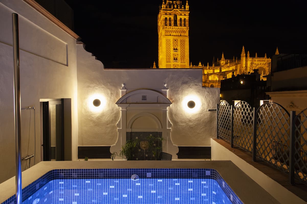 Una piscina en la azotea con vistas a una torre histórica y un castillo.