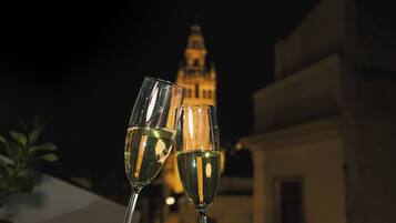 Two champagne flutes in front of a building with a tower at night.