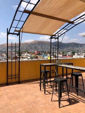 Una terraza con vistas a una ciudad y montañas.