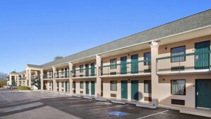 A row of motel buildings with a parking lot in front. - Days Inn by Wyndham Lexington (Lexington)