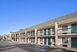 A row of motel buildings with a parking lot in front. - Days Inn by Wyndham Lexington (Lexington)