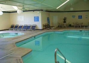 An indoor swimming pool with multiple lanes, lounge chairs, and a sunbed area. - FREE Amenity Passes Spacious Sauna Large Deck Firepit (Lehman township)